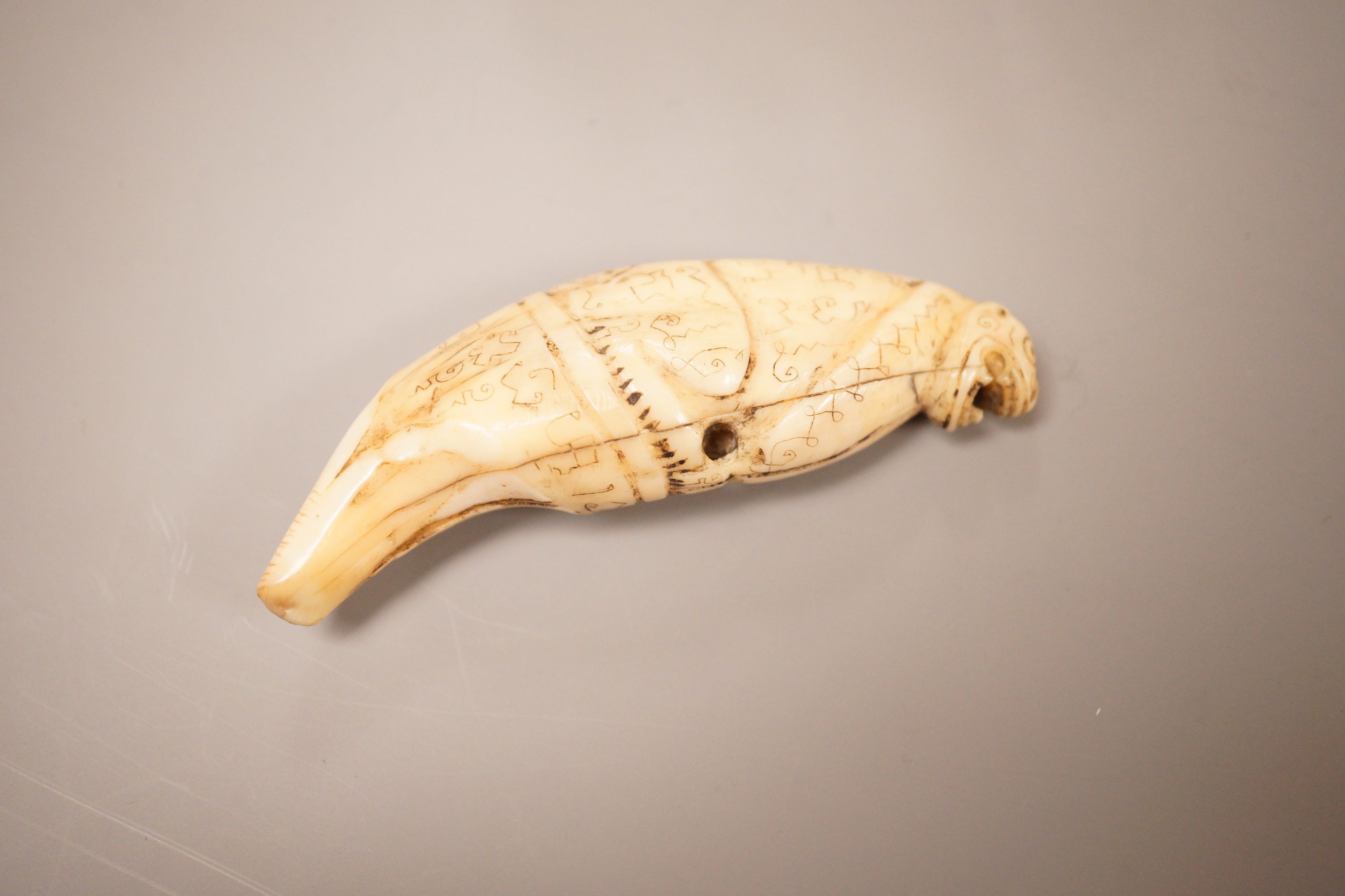 An Inuit whale tooth carving, 19th century, 8cm long, and a marine ivory religious group, possibly Goa
